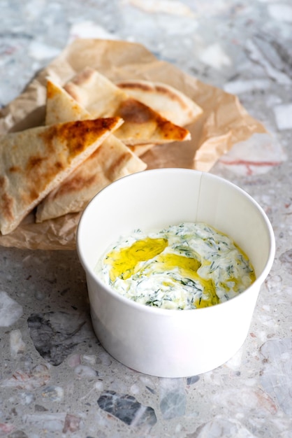 Trempette grecque traditionnelle Tzatziki faite avec de la crème sure au concombre, du yogourt grec, du jus de citron, de l'huile d'olive et un brin frais d'aneth