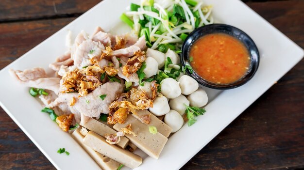 Trempette de porc bouillie avec sauce piquante et acidulée (cuisine thaïlandaise).