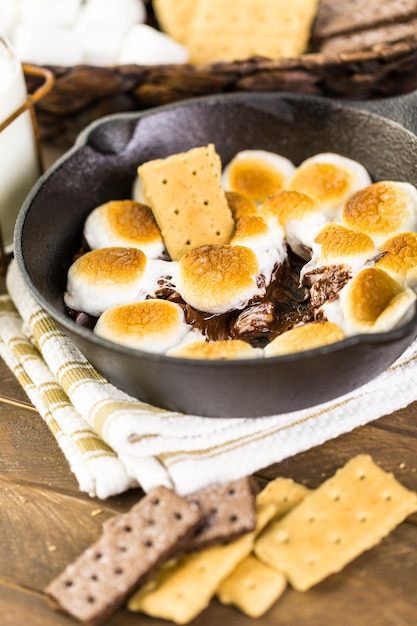 Trempette Smores préparée avec de grosses guimauves dans une poêle en fonte.