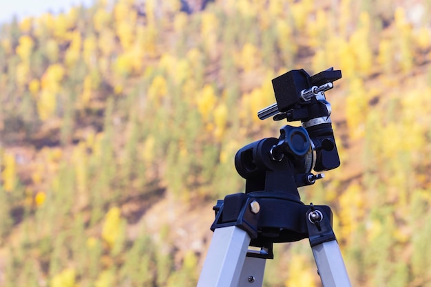 Trépied de caméra sur fond naturel mise au point sélective à l'extérieur avec espace de copie Attaches de télescope