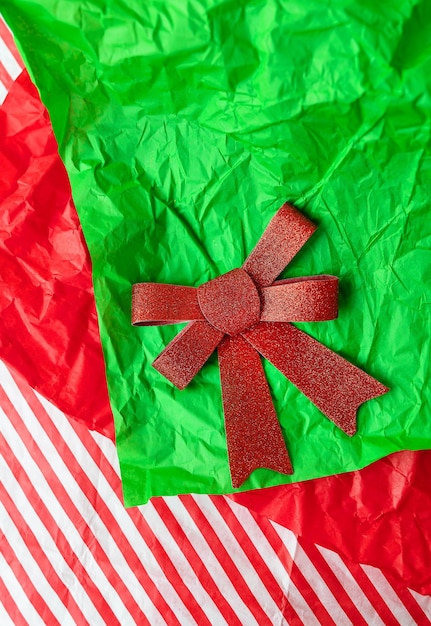 Très bel arc rouge brillant allongé sur du papier cadeau concept d'emballage cadeau et célébration de Noël et du Nouvel An Vue d'en haut