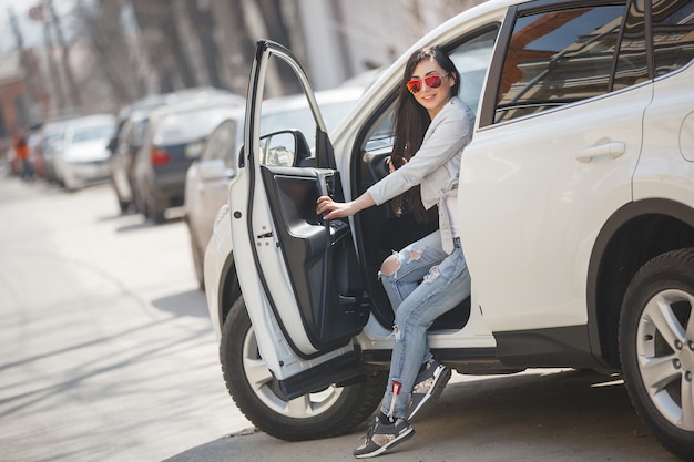 Très belle femme dans la voiture tenant des fleurs