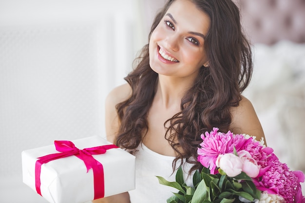 Très belle femme avec pivoine et coffret cadeau à l'intérieur