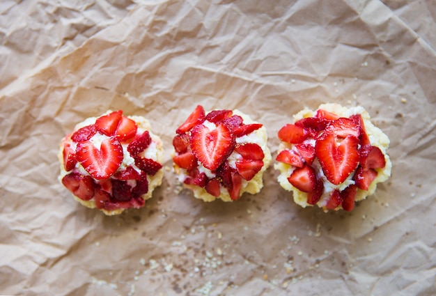 De très bons muffins aux fraises fraîches se trouvent sur du papier kraft