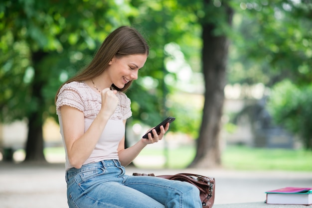 Très heureuse femme regardant son téléphone portable