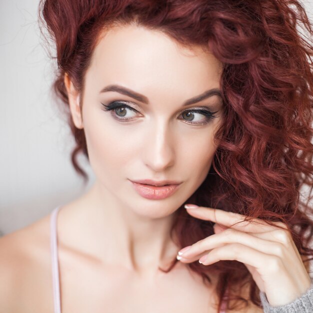 Très jolie jeune femme à l'intérieur. Portrait de femme aux cheveux bouclés. Belle femme rousse à la maison.