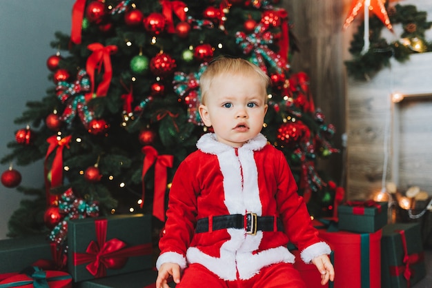 Très mignon petit garçon de bébé en bas âge portant le costume de Père Noël