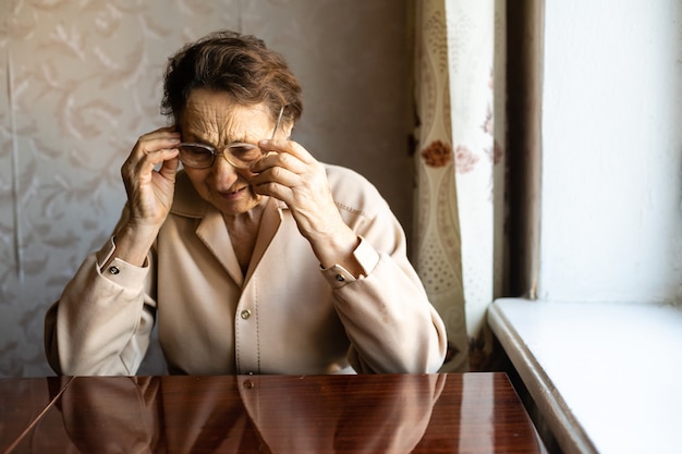 très vieille femme met des lunettes