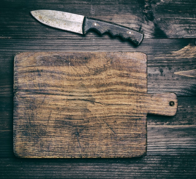 Très vieille planche à découper en bois marron et couteau
