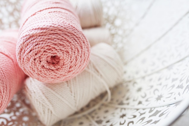 Tressage de macramé fait à la main et fils de coton dans un panier blanc Cordons et cordes de macramé en coton