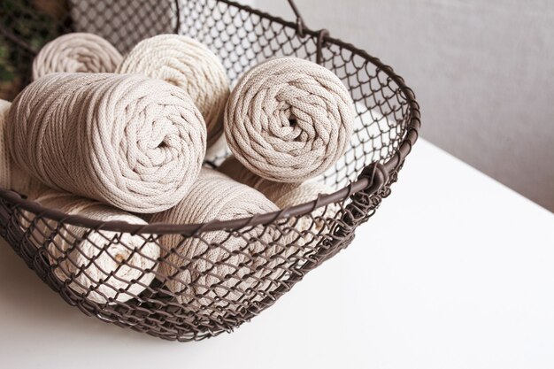 tressage en macramé fait main et fils de coton naturel dans un panier sur fond blanc avec des ombres