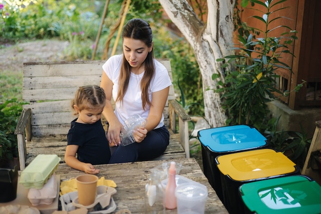 Tri des ordures en famille à la maison sur le concept d'arrière-cour de recyclage à l'extérieur maman et fille s'occupant