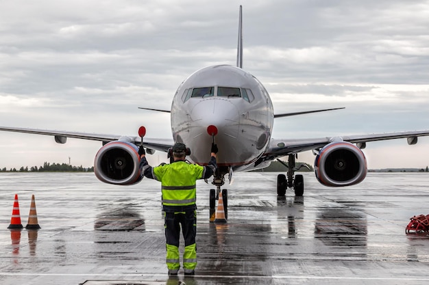 Triage d'avions à l'aire de trafic de l'aéroport par temps de pluie. Réunion d'avions de passagers