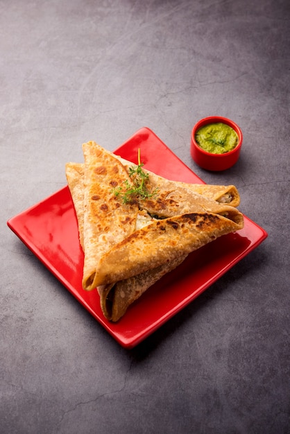 Triangle Paratha Wrap avec garniture de poulet aux pommes de terre servi avec chutney vert, cuisine indienne
