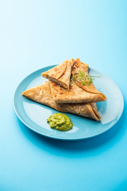 Triangle Paratha Wrap avec garniture de poulet aux pommes de terre servi avec chutney vert, cuisine indienne