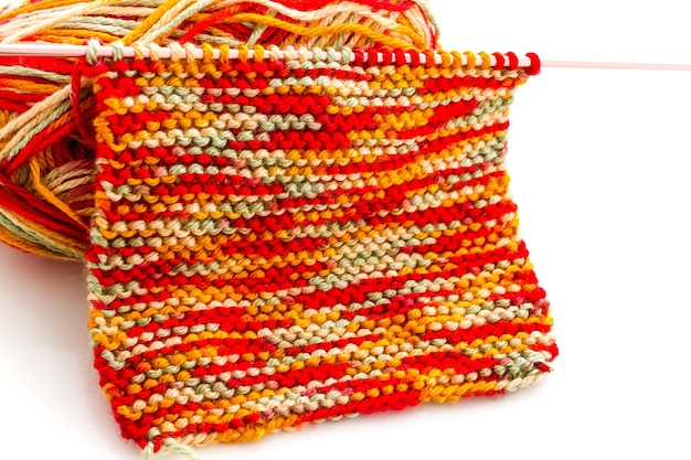 Tricoter avec des fils multicolores avec des tons orange, rouge et jaune.