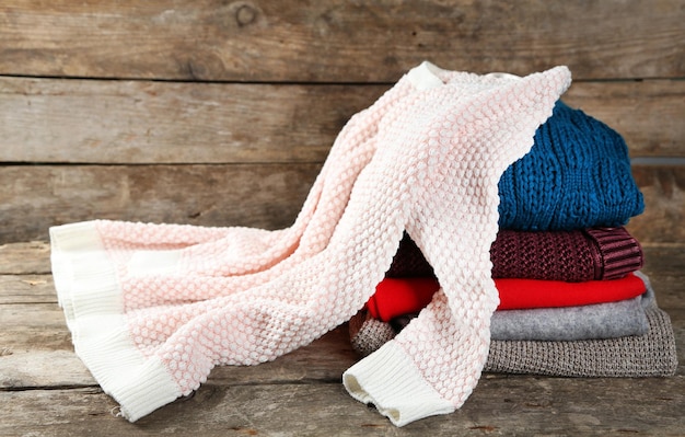 Photo tricoter des vêtements sur fond de bois