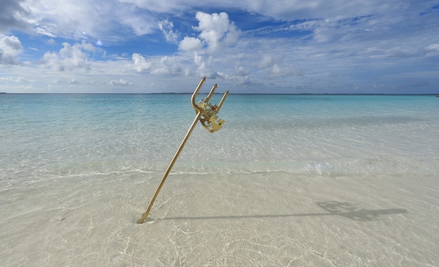 trident d'or et couronne sur l'océan