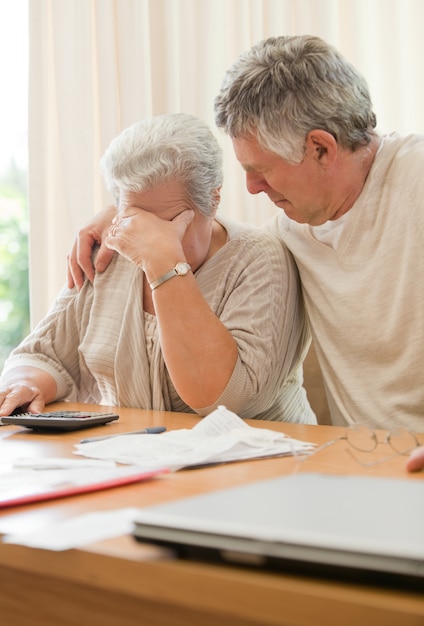 Triste couple d&#39;âge mûr calculant leurs factures domestiques