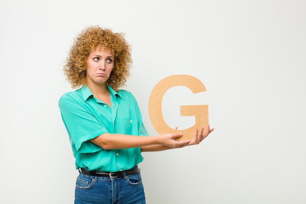 triste, déprimé, malheureux, tenant la lettre G de l'alphabet pour former un mot ou une phrase.