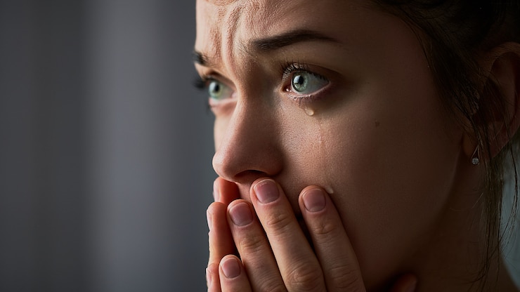 Photo triste désespérée pleurer pleurer femme avec les mains jointes et les larmes aux yeux pendant les ennuis