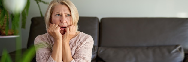 Triste femme adulte assise sur le canapé