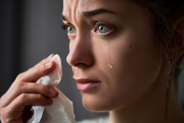 Triste femme qui pleure et pleure avec des larmes aux yeux pendant les ennuis