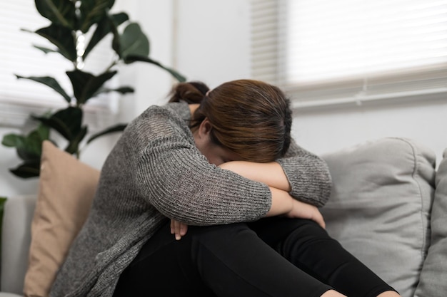 Triste femme en surpoids grande taille pensant à des problèmes sur le canapé fille bouleversée se sentant seule et triste à cause d'une mauvaise relation ou d'un trouble de santé mentale d'une femme déprimée