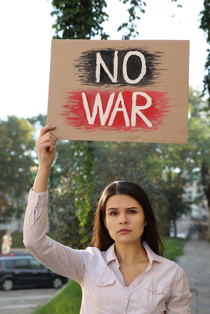 Triste femme tenant une affiche avec des mots Pas de guerre dans la rue de la ville