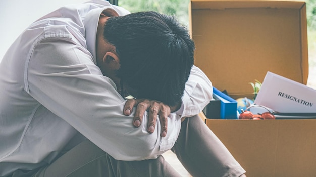 Triste homme d'affaires licencié assis à l'extérieur du bureau après avoir perdu son emploi