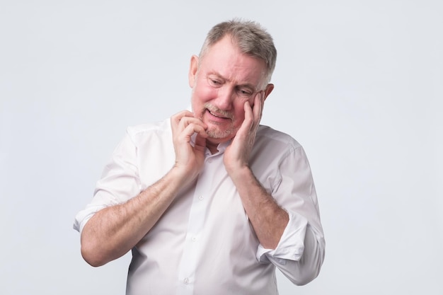 Triste homme âgé en chemise blanche pensant à la vie du travail