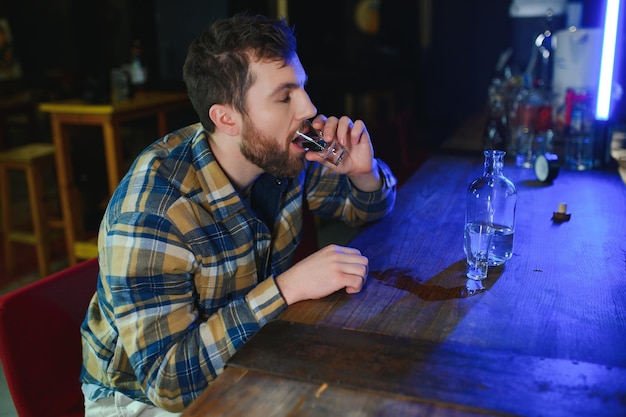 Triste homme assis au comptoir du bar dépendance à l'alcool