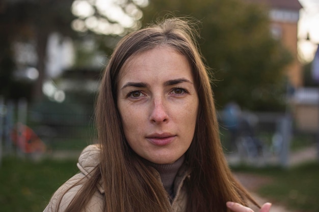 Triste jeune femme aux cheveux longs dans une veste dans la rue