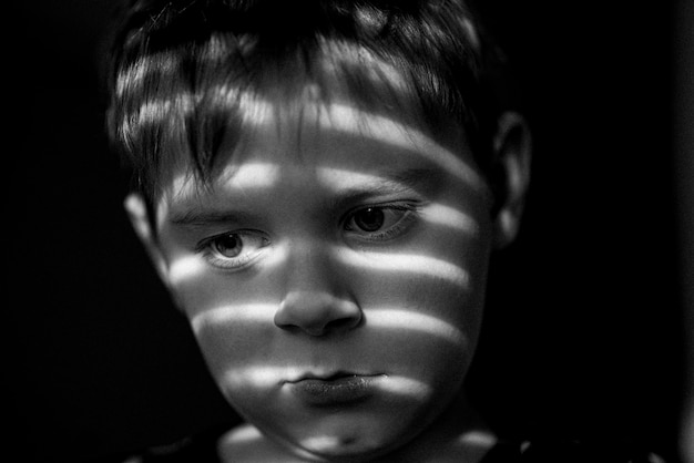 Triste jeune garçon L'enfant est déprimé offensé Photo monochrome