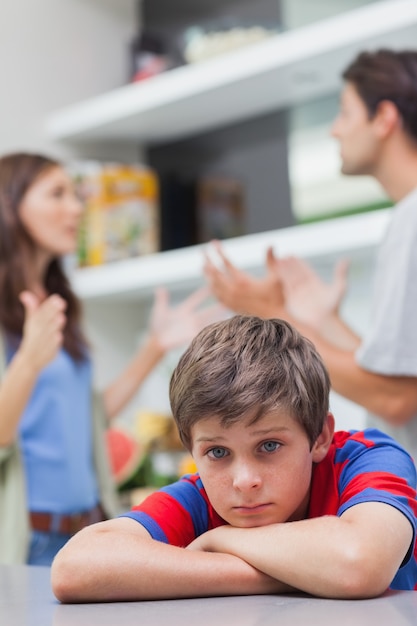 Triste petit garçon écoutant ses parents se disputer