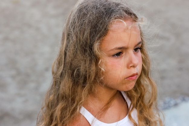 Triste petite fille aux longs cheveux flottants