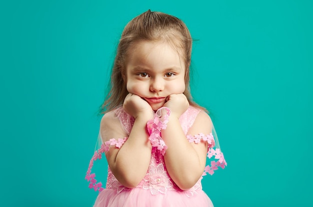 Triste petite fille s'ennuie a un visage frustré, portrait d'enfant de mauvaise humeur sur bleu isolé