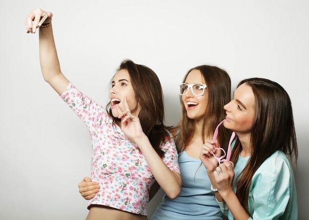 Trois adolescentes heureux avec smartphone prenant selfie