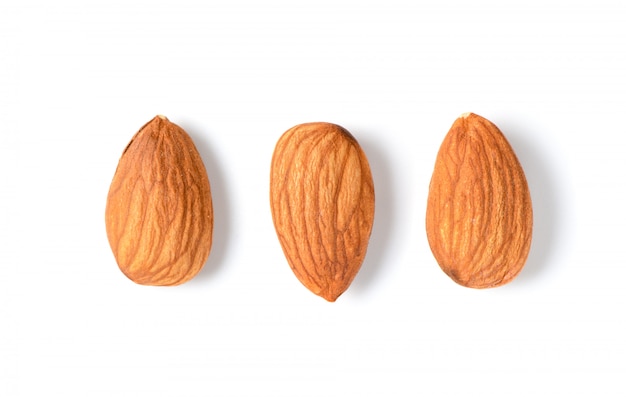 Trois amandes pelées isolés sur fond blanc.