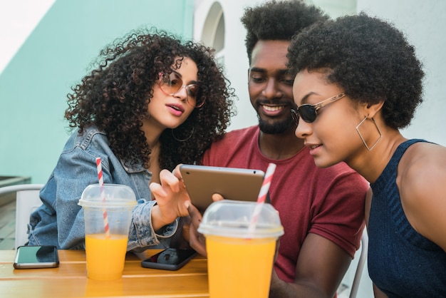 Trois amis afro à l'aide de tablette numérique.