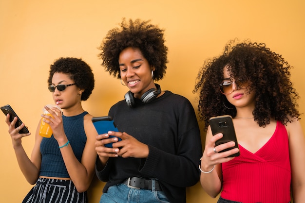 Trois amis afro utilisant leur téléphone portable