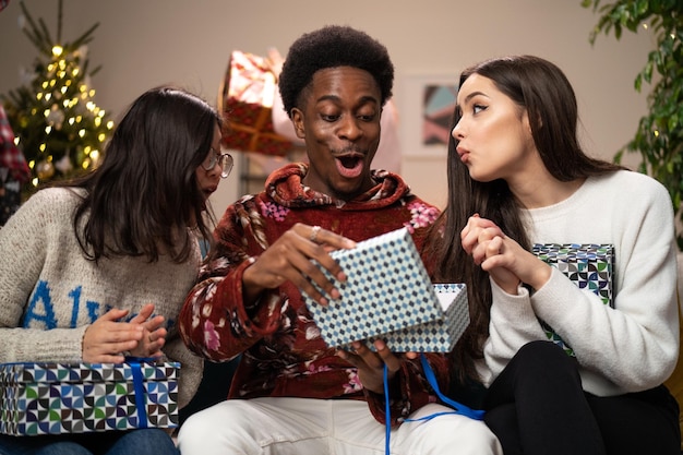 Trois amis sont assis sur le canapé le soir de noël les femmes