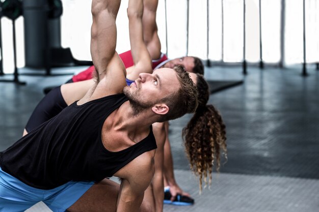 Trois athlètes musclés qui s&#39;étendent ensemble