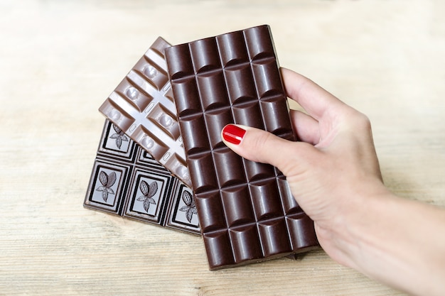 Trois Barres De Chocolat De Différents Types Dans Une Main Féminine