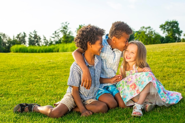 Trois Beaux Enfants Jouent Sur La Clairière Ensoleillée Avec Un Sourire Et S'amusent