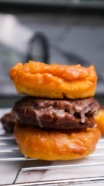 Trois beignets empilés les uns sur les autres, l'un étant glacé.