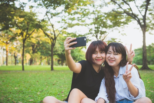 Trois belles amies étant modernes en prenant des selfies.