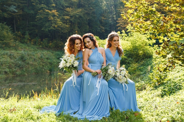 Trois belles demoiselles d'honneur dans le parc le jour du mariage