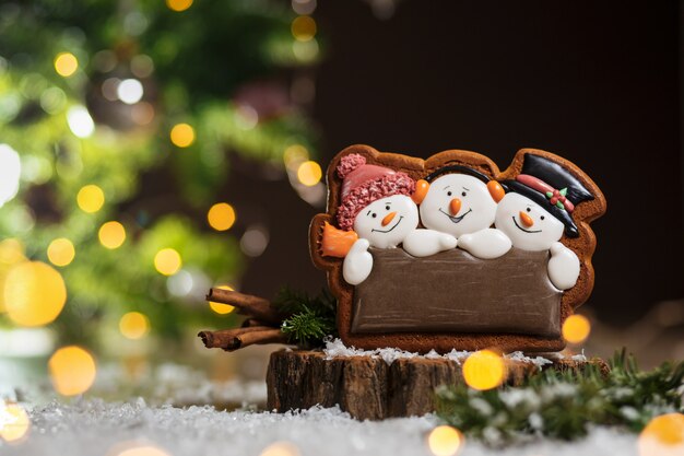 Trois bonhommes de neige en pain d'épice à la décoration chaleureuse et confortable avec des guirlandes