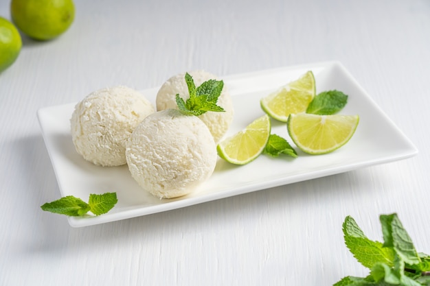 Trois boules de crème glacée un aliment surgelé sucré consommé comme collation ou dessert sur une assiette avec du citron vert